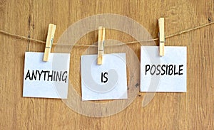 Anything is possible symbol. Concept words Anything is possible on beautiful white paper on clothespin. Beautiful wooden table