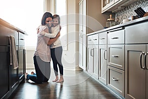 Anytime is cuddle time. a happy mother hugging her cute little girl in the kitchen at home.