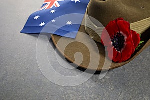 Anzac army slouch hat with Australian Flag and Poppy on stone background