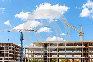 Apartment building construction site. industrial cranes at blue sky