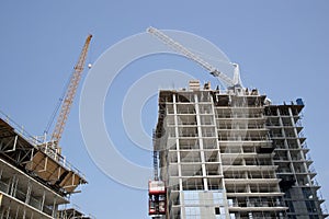 Apartment building with cranes on the construction site