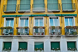 Apartment building facade with balcony flowers Mediterranean style
