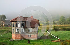 The apartment building is in front of a thick layer of fog. Living in a mountainous area in the Carpathians, Ukraine