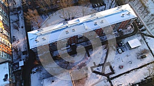 Apartment building with snow capped roof and empty yard