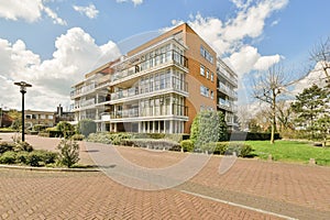 an apartment building with a brick driveway and a lawn