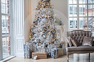 The apartment is decorated with a Christmas tree, under the tree are gifts