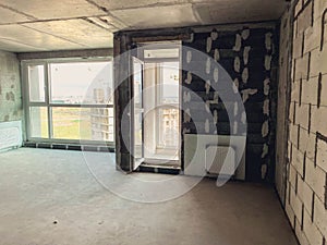 Apartment without finishing and repair. walls made of concrete blocks, bricks, with a balcony and panoramic windows. batteries