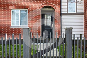 Apartment house, residential building complex with gate. Exterior of a house with front door and wooden fence and gate