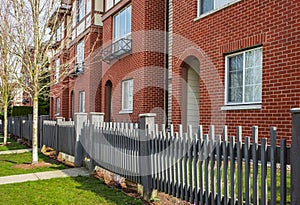 Apartment house, residential building complex with gate. Exterior of a house with front door and wooden fence and gate