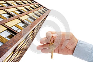 Apartment key in a man`s hand. Brass house door lock key. Modern building, view from below.