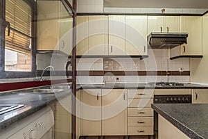 Apartment kitchen with beige cabinets with drawers and doors