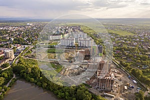 Apartment or office brick buildings under construction, top view. Building site with tower cranes from above. Drone aerial