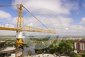 Apartment or office tall building under construction. Brick walls, glass windows, scaffolding and concrete support pillars. Tower