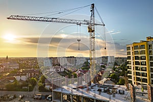 Apartment or office tall building under construction. Brick walls, glass windows, scaffolding and concrete support pillars. Tower