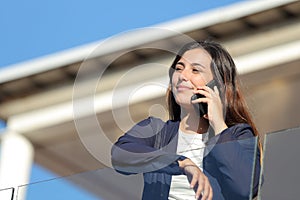 Apartment renter calling on phone in a balcony photo