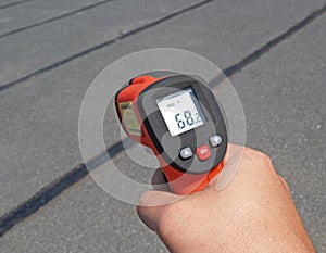 Apartment rooftop summer temperature on a block probed with an infrared thermometer