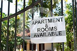 Apartment and rooms available, an advertisement on the gate for a house for rent photo