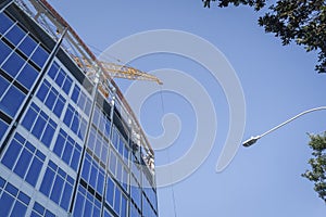 Apartment under construction. Construction crane above the building against the bright blue sky. Auckland