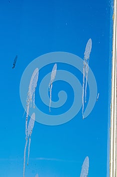 apartment windows against blye sky and dirty glass