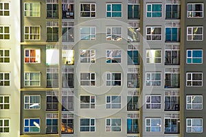 Apartment windows at night in new condo highrise building full o