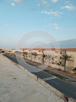 Apartments. Resdentials. Residential road. Palm trees. Blue skies. Outdoor. Zebra crossing. Modern apartments.