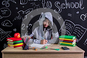 Apathetic and uninterested youngster sitting at the desk with a straight view to the camera with the view under the