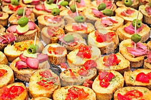 Aperitif buffet with appetizers and bruschetta with tomatoes, olives, sauces and salami