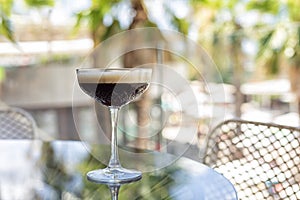 Aperitif with CaffÃ¨ shakerato in a tall glass, in an outdoor italian cafe, palms photo