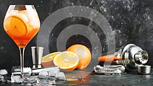 Aperol spritz cocktail in big wine glass, summer Italian low alcohol cold drink, dark bar counter background with tools, copy