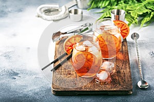 Aperol spritz cocktail in wine glass with sparkling wine, liqueur, ice cubes and red orange - summer Italian low alcohol cold
