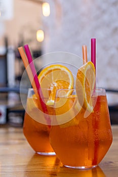 Aperol-Spritz-Drinks with orange slices ond colourful straws