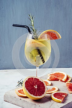 Aperol spritz garnish in wine glasses with rosemary and grapefruit on luxury marble table. Bitter sparkling champagne alcohol