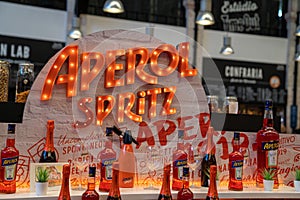 Aperol Spritz orange neon logo and display at custom bar at Time Out Market Lisbon