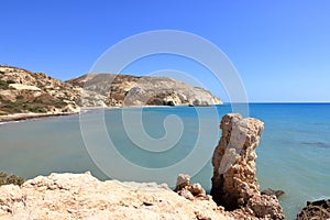 Aphrodite Beach with Stone Rocks in Aphrodite bay of Mediterranean sea water, blue sky in sunny day background, Petra tu Romiou, photo