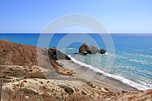Aphrodite Beach with Stone Rocks in Aphrodite bay of Mediterranean sea water, blue sky in sunny day background, Petra tu Romiou, photo