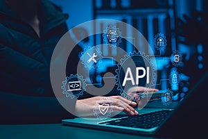 API Application Programming Interface concept. Person using laptop with digital gear icons, representing software integration,