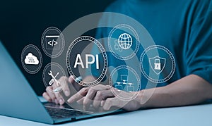 API Application Programming Interface Concept. A programmer types on a laptop, interacting with digital icons representing API