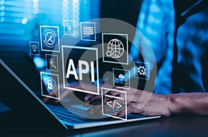 API Application Programming Interface Concept. A programmer types on a laptop, interacting with digital icons representing API