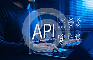 API Application Programming Interface Concept. A programmer types on a laptop, interacting with digital icons representing API