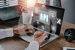 API - Application Programming Interface, Man using laptop computer with touch screen interface and select API icon