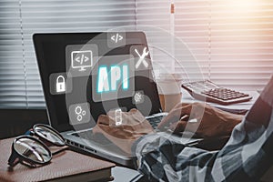 API - Application Programming Interface, Man using laptop computer with touch screen interface and select API icon, Software