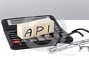 API concept on wooden cubes on calculator on white background