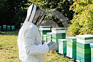 apiarist in beekeeping suit and helmet