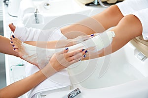 Aplying nourishing moisturizer mask woman legs