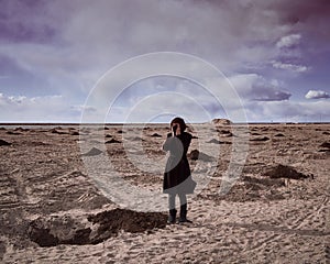 Apocalypse and cataclysm due to coronavirus. Woman in black mask and black coat. Surreal landscape