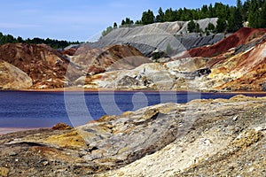 Apocalyptic landscape like a planet Mars surface. Fantastic view of crimson red lake. Solidified red-brown black Earth surface.