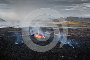 Apocalyptic surroundings of an erupted volcano, lava and smoke spreading, aerial photo