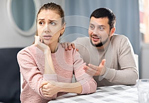 Apologetic husband calming upset wife after spat at home