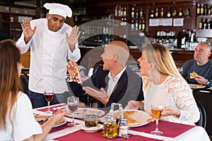 Apologetic pizzeria chef talking to dissatisfied guests