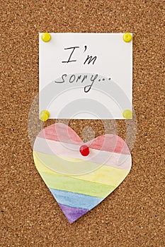 Apologize, I am sorry inscription text written on white paper pined on cork board